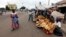 Street vendors sell loaves of bread and other wares on a street in Bouake, Ivory Coast, December 2010.