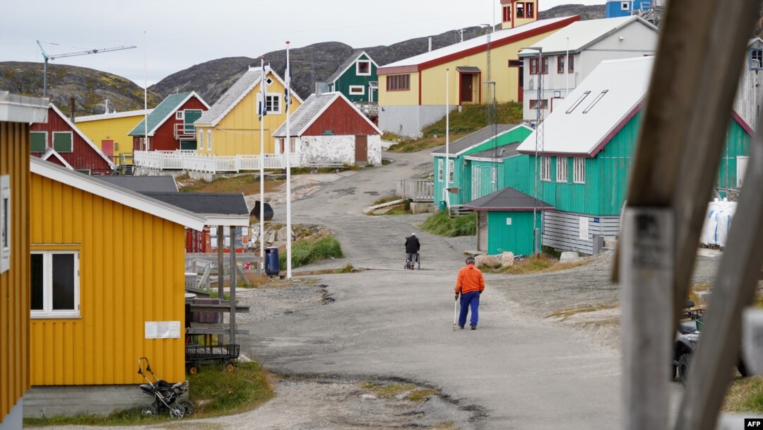 Warga lokal tampak berjalan di wilayah Kangaamiut, di pesisir barat Greenland, pada 4 September 2024. (Foto: AFP/James Brooks)