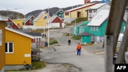 Warga lokal tampak berjalan di wilayah Kangaamiut, di pesisir barat Greenland, pada 4 September 2024. (Foto: AFP/James Brooks)