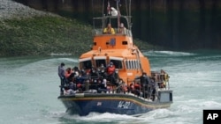Un grupo de presuntos migrantes es llevado a Dover a bordo de un bote de las autoridades, en Kent, Inglaterra, el 4 de julio de 2021.