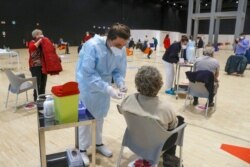 Medical staff members administer the AstraZeneca vaccine at La Nuvola (The Cloud) convention center, in Rome, March 19, 2021. Italy's pharmaceutical agency has formally lifted its temporary ban on AstraZeneca vaccinations.
