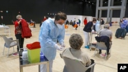 Medical staff members administer the AstraZeneca vaccine at La Nuvola convention center, in Rome, March 19, 2021. 