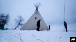 Snow lays on the ground as campers from Colorado set up a teepee at the Oceti Sakowin camp where people have gathered to protest the Dakota Access oil pipeline near Cannon Ball, N.D., Nov. 30, 2016.