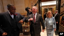 FILE - In this March 9, 2020 file photo, Louisiana Gov. John Bel Edwards, center, bumps elbows with state Rep. Patrick Jefferson, instead of a traditional handshake, as a precaution against the new coronavirus.