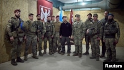 Ukraine's President Volodymyr Zelenskyy, center, and his nation's armed forces chief, General Oleksandr Syrskyi, at the president's left, are pictured with service members in the Sumy region, Ukraine, Oct. 4, 2024. (Ukrainian Presidential Press Service)