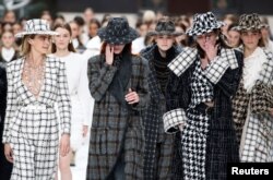 Models react while presenting creations by late designer Karl Lagerfeld as part of his Fall/Winter 2019-2020 women's ready-to-wear collection show for fashion house Chanel at the Grand Palais during Paris Fashion Week in Paris, France, March 5, 2019.
