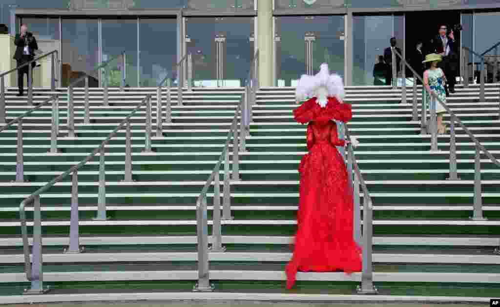 Debora Day in an ornate red outfit poses on the steps for photographers on the third day of the Royal Ascot horserace meeting, which is traditionally known as Ladies Day, in Ascot, England.
