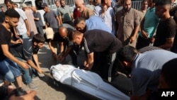 Los dolientes cargan el cuerpo de una persona muerta en un ataque israelí en el patio del hospital de los Mártires de al-Aqsa en Deir el-Balah, en el centro de la Franja de Gaza, el 20 de julio de 2024, en medio del conflicto en curso entre Israel y el movimiento palestino Hamas.