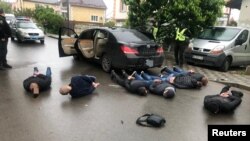 Ukrainian police officers detain men who are suspected of taking part in a recent armed conflict, in the town of Brovary, Ukraine May 29, 2020. (Press Service of National Police of Ukraine/Handout via Reuters)