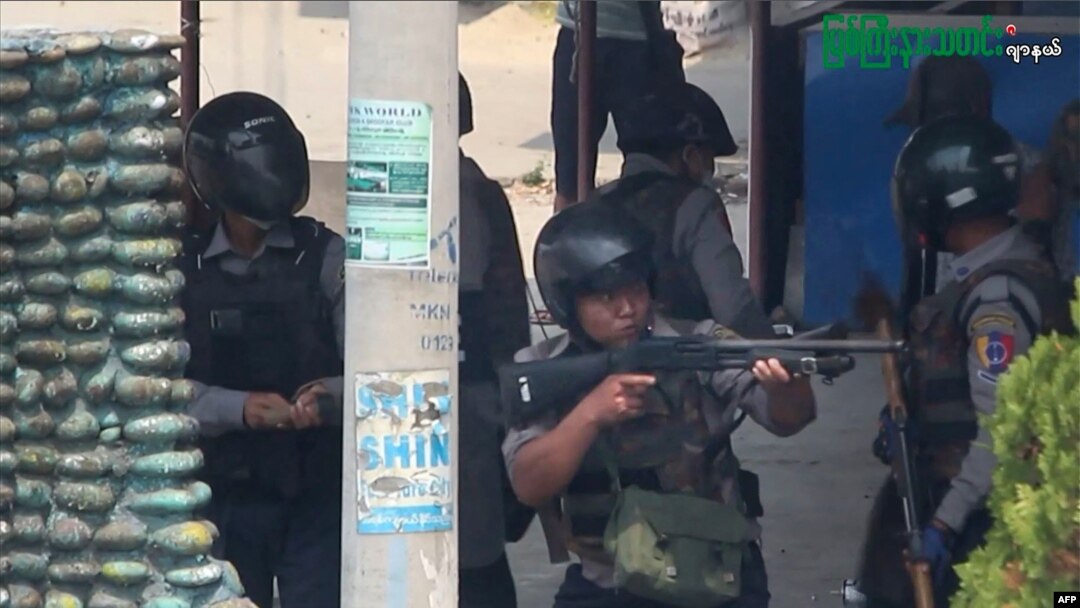 Dalam foto dari tangkapan layar AFPTV dan siaran Myitkyina News Journal tampak polisi membidik senjatanya saat menindak demonstrasi antikudeta di Myitkyina di negara bagian Kachin, Myanmar, Sabtu, 27 Maret 2021. (Foto: AFP dan sumber lain)