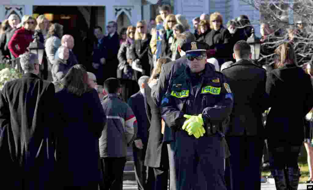 A police officer stands outside as a service begins for teacher Anne Marie Murphy at the St. Mary Of The Assumption Church in Katonah, New York, December 20, 2012.