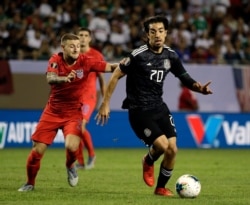 Mexico's Rodolfo Pizarro, right, controls the ball against U.S. forward Paul Arriola during the Gold Cup final in Chicago, July 7, 2019. Mexico won 1-0.