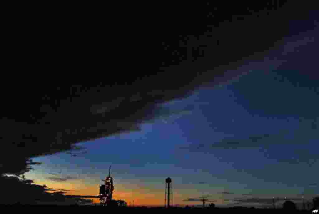 Storm clouds roll over the space shuttle Discovery after sunset Wednesday, Nov. 3, 2010, at the Kennedy Space Center in Cape Canaveral, Fla. Space shuttle Discovery's launch Thursday was postponed, due to stormy weather. (AP Photo/Terry Renna)