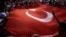 Protesters wave a large Turkish flag during an anti-coup rally in Taksim Square in Istanbul, July 25, 2016. 