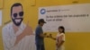 Una pareja se encuentra frente a un mural político del presidente Nayib Bukele, el mensaje: "Ordeno que vendan 3 pupusas por un dólar", parte de una ofensiva del gobierno para bajar los precios de los alimentos, en San Salvador, El Salvador, el viernes 12 de julio de 2024.