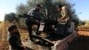 Des combattants syriens soutenus par la Turquie chargent des munitions sur une ligne de front près de la ville de Saraqib dans la province d'Idlib, en Syrie, mercredi, février. 26, 2020.