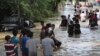 Warga berjalan mengarungi banjir di Tanggerang, Kamis, 2 Januari 2020. (Foto: Tatan Syuflana/AP)