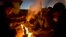 Afghan refugees gather around a fire to warm themselves in the early hours while waiting to get on board a ferry traveling to Athens, at the port of Mitylene on the northeast Greek island of Lesbos, Oct. 9, 2015.