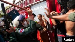 Police use batons against garment workers during clashes in Phnom Penh, Cambodia, Nov. 12, 2013. 