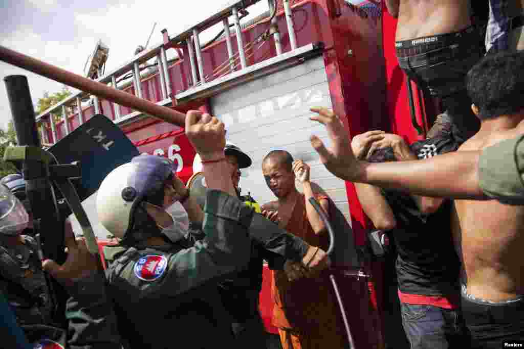 Police use batons against garment workers during clashes in Phnom Penh, Cambodia, Nov. 12, 2013. 
