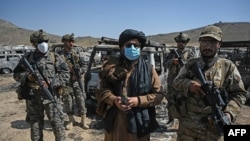 塔利班成员站在位于喀布尔东北部被摧毁的美国中央情报局 (CIA) 基地附近（法新社 2021年9月6日）