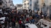 People gather as smoke rises from a UN school-turned-shelter after it was hit in an Israeli strike, in the Rimal neighborhood of Gaza City in the northern Gaza Strip on Nov. 14, 2024.