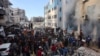 FILE - People gather as smoke rises from a UN school-turned-shelter after it was hit in an Israeli strike, in the Rimal neighborhood of Gaza City in the northern Gaza Strip on Nov. 14, 2024.