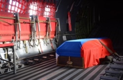 FILE - The Russian flag-covered coffin of Russian pilot Lt. Col. Oleg Peshkov is shown inside a Russian air force transport plane at Esenboga Airport in Ankara, Turkey, Nov. 30, 2015. He was killed when Turkish F-16s shot his plane down.