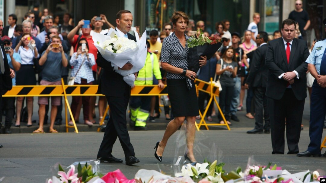 PM Australia Tony Abbott dan istrinya Margie, bersama massa pelayat meletakkan bunga di lokasi peringatan sementara bagi korban penyanderaan di Sydney, Selasa (16/12).