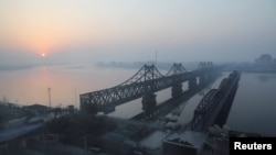 중국 랴오닝성 단둥에서 바라본 일출 무렵의 압록강 풍경. 북한 신의주와 중국의 경계인 압록강 위로 조중우의교와 압록강 단교.