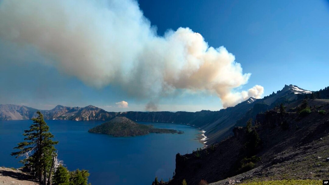 This photo provided by Inciweb.gov, shows smoke from Bybee Creek Wildfire drifting over Crater Lake, Oregon., July 30, 2016. 