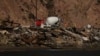 A cement truck and workers are seen from the water among beachfront homes destroyed by the Palisades Fire, Jan. 15, 2025, in Malibu, California.