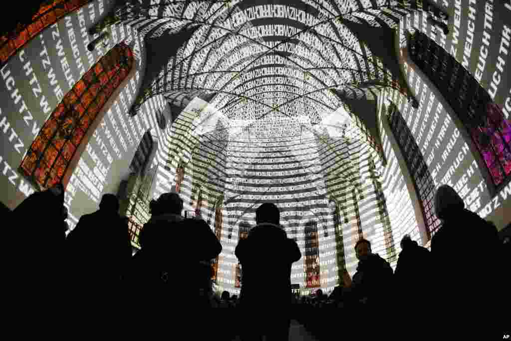 Spectators watch letters being projected on the walls inside the Katharinen church as a part of the &quot;Luminale&quot; light show in Frankfurt, Germany, March 15, 2016.