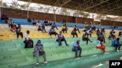 Les personnes qui n'ont pas respecté les mesures de prévention du coronavirus sont obligées d'écouter les discours de prévention pendant des heures au stade Nyamirambo de Kigali, au Rwanda, le 3 août 2020. (Photo: STR / AFP)