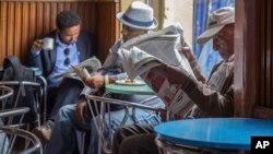 FILE - Ethiopian men read newspapers and drink coffee at a cafe during a declared state of emergency in Addis Ababa, Ethiopia. 