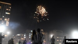 Sepasang kekasih merayakan malam Tahun Baru, di tengah wabah Covid-19, di Pantai Copacabana di Rio de Janeiro, Brazil, 1 Januari 2021. (Foto: REUTERS/Lucas Landau)