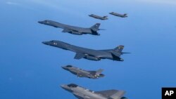 FILE - In this photo provided by South Korea Defense Ministry, U.S. Air Force B-1B bombers, center, fly in formation with South Korea's Air Force F-35A fighter jets over the South Korea Peninsula during a joint air drill in South Korea, March 19, 2023.