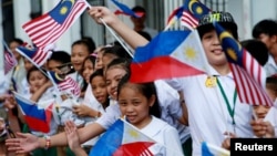 Children wave Philippine and Malaysian flags as they wait for the arrival of Malaysian Prime Mahathir Bin Mohamad at the Malacanang presidential palace in Manila, Philippines, March 7, 2019. 