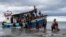 Local fisherman help ethnic-Rohingya people as they arrive on Lancok Beach, North Aceh, Indonesia, Thursday, June 25, 2020. Indonesian fishermen discovered dozens of the hungry, weak Rohingya Muslims on the wooden boat adrift off Indonesia's…