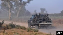 FILE - Members of the Cameroonian Rapid Intervention Battalion patrol on the outskirts of Mosogo in the far north region of the country, March 21, 2019.