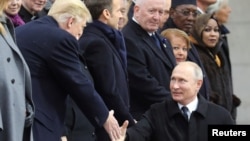 Le président russe Vladimir Poutine serre la main du président américain Donald Trump à l’occasion de a commémoration du Jour de l’armistice, cent ans après la fin de la Première Guerre mondiale, à l’Arc de Triomphe, à Paris, le 11 novembre 2018.