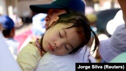 Seorang bocah kecil tertidur ketika menunggu kedatangan Paus Fransiskus di Gereja Paroki Santo Petrus, Nakhon Pathom, Thailand, 22 November 2019. (Foto: REUTERS/Jorge Silva)