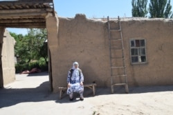 Aziz Isa Elkun’s mother sits in front of her house in Xinjiang, China, April 2019, in this scene from the film "An Unanswered Telephone Call" (Courtesy Aziz Isa Elkun)