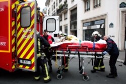 FILE - An injured person is transported to an ambulance after a shooting at the French satirical newspaper Charlie Hebdo's office, in Paris, Jan. 7, 2015.
