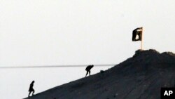 Gambar yang diambil dengan lensa tele dari Suruc, perbatasan Turki-Suriah ini menampilkan militan ISIS setelah menancapkan bendera kelompok mereka di puncak bukit si sabelah timur kota Kobani, Suriah (Foto: dok).