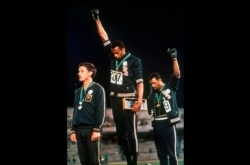 FILE - In this Oct. 16, 1968 file photo, U.S. athletes Tommie Smith, center, and John Carlos raise their gloved fists after Smith received the gold and Carlos the bronze for the 200 meter run at the Summer Olympic Games in Mexico City.