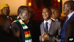 Zimbabwean President Emmerson Mnangagwa, left, arrives at Robert Mugabe International Airport in Harare, Zimbabwe, Monday, Jan. 21, 2019.