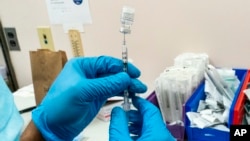 Pharmacist prepares a syringe with Pfizer’s vaccine at a COVID-19 vaccination site. (File)