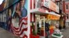 Seorang pelanggan mengenakan masker, keluar dari restoran Ben's Chili Bowl, di tengah pandemi Covid-19 di Washington, D.C., 30 April 2020. (REUTERS/Jonathan Ernst).