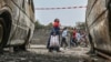 Residents walk by charred vehicles in Goma, Democratic Republic of the Congo, Jan. 31, 2025.